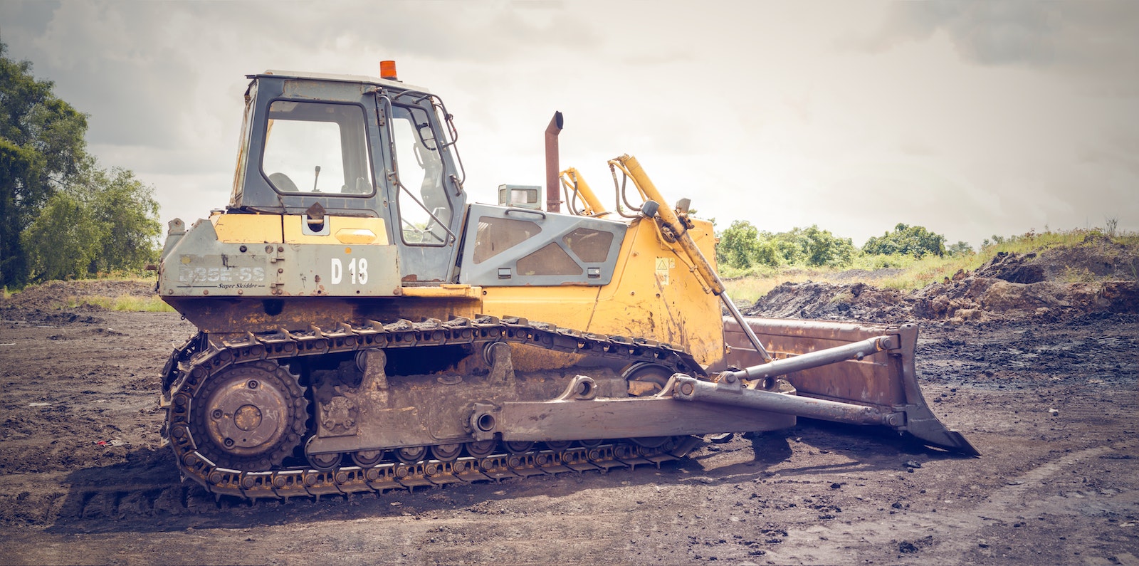 Yellow and Brown Metal Pay Loader on He Dirt